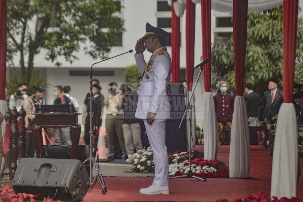 Gubernur Jawa Barat, Ridwan Kamil sedang melakukan penghormatan kepada bendera Merah Putih yang sedang dibentangkan.