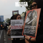 Potret dua peserta aksi kampanye kawasan Dago Elos membawa poster berisi pesan perjuangan yang bertempat di depan Terminal Dago, Jl. Dago Elos II, Kota Bandung, pada Sabtu, (4/7).