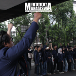 Sejumlah mahasiswa mengepalkan tangan saat mengikuti aksi menjelang dua tahun pemerintahan Prabowo-Gibran di perempatan Taman Cikapayang Dago pada Selasa, (13/10).     (Foto: Siska Vania/SM).